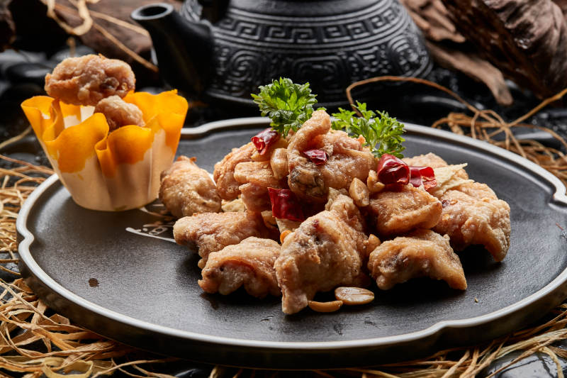 黑色陶餐具装的香炸三黄鸡块