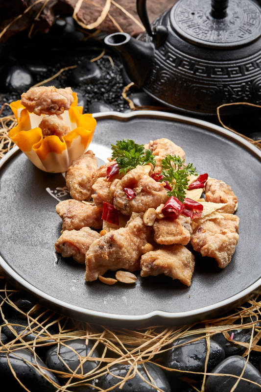 黑色陶餐具装的香炸三黄鸡块