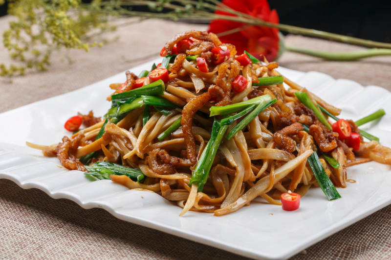 白色瓷盘装的的彩椒小炒双菇