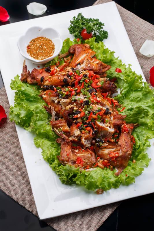 陈旧木板上的方瓷盘装的风味手撕兔