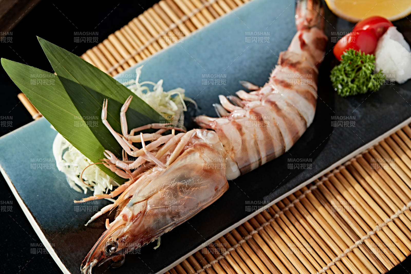 长方形瓷盘装的铁板野生明虾皇摆放在草垫上