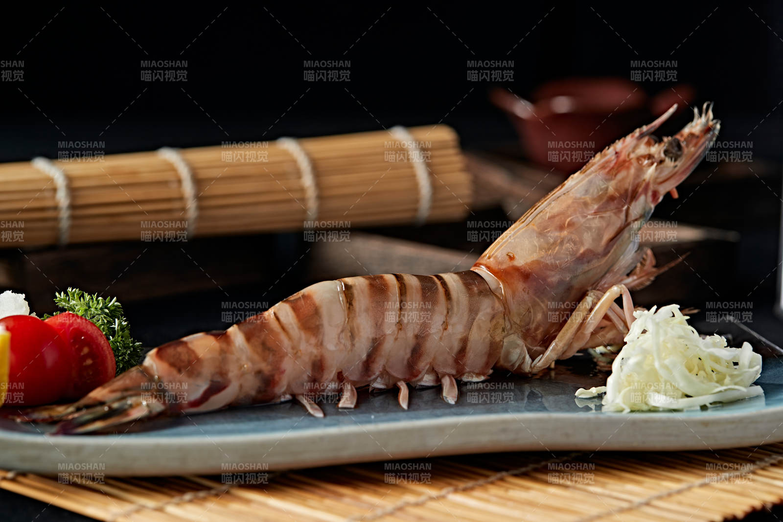 长方形瓷盘装的铁板野生明虾皇摆放在草垫上