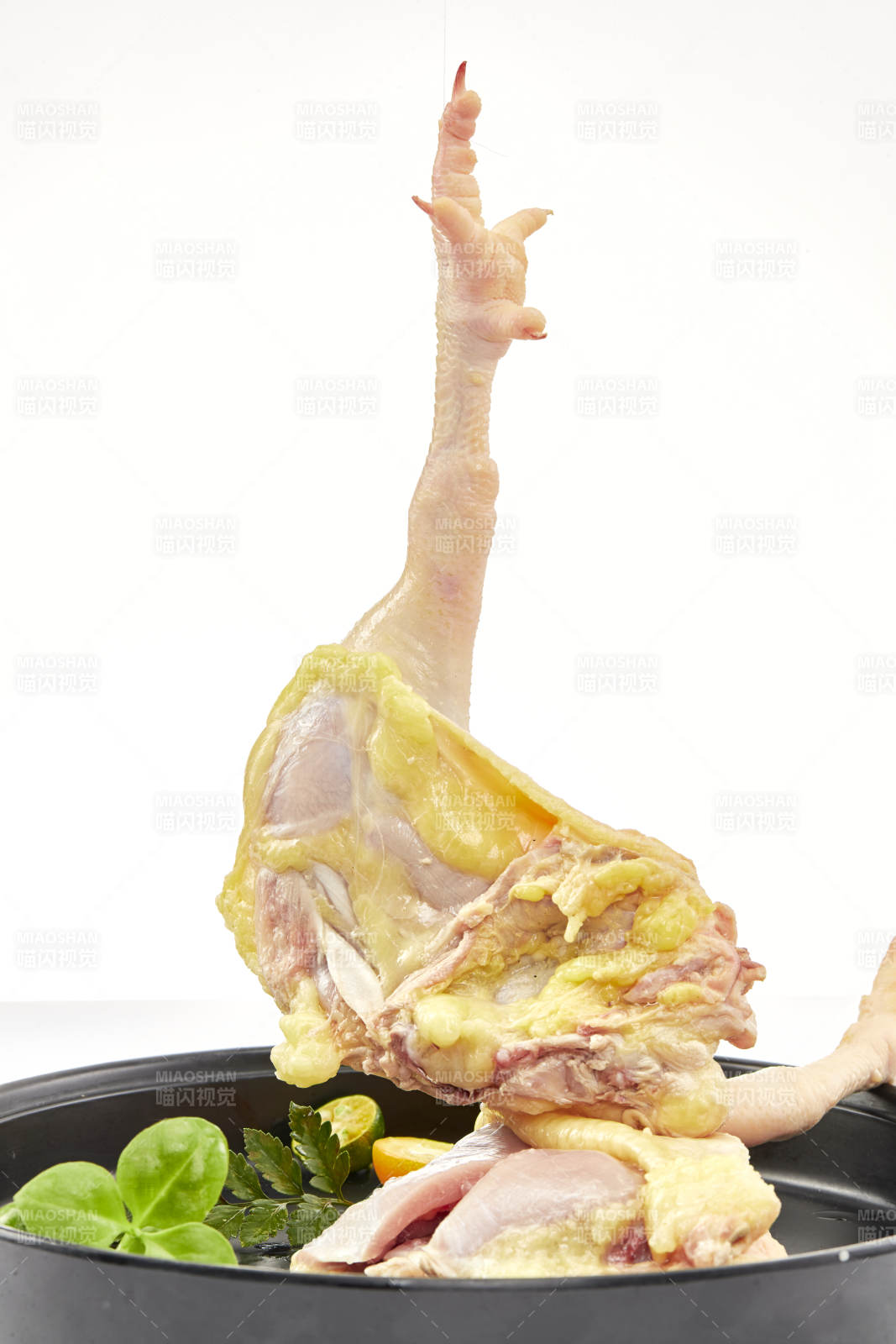 摆放在白色背景上分切好的生鲜鸡腿