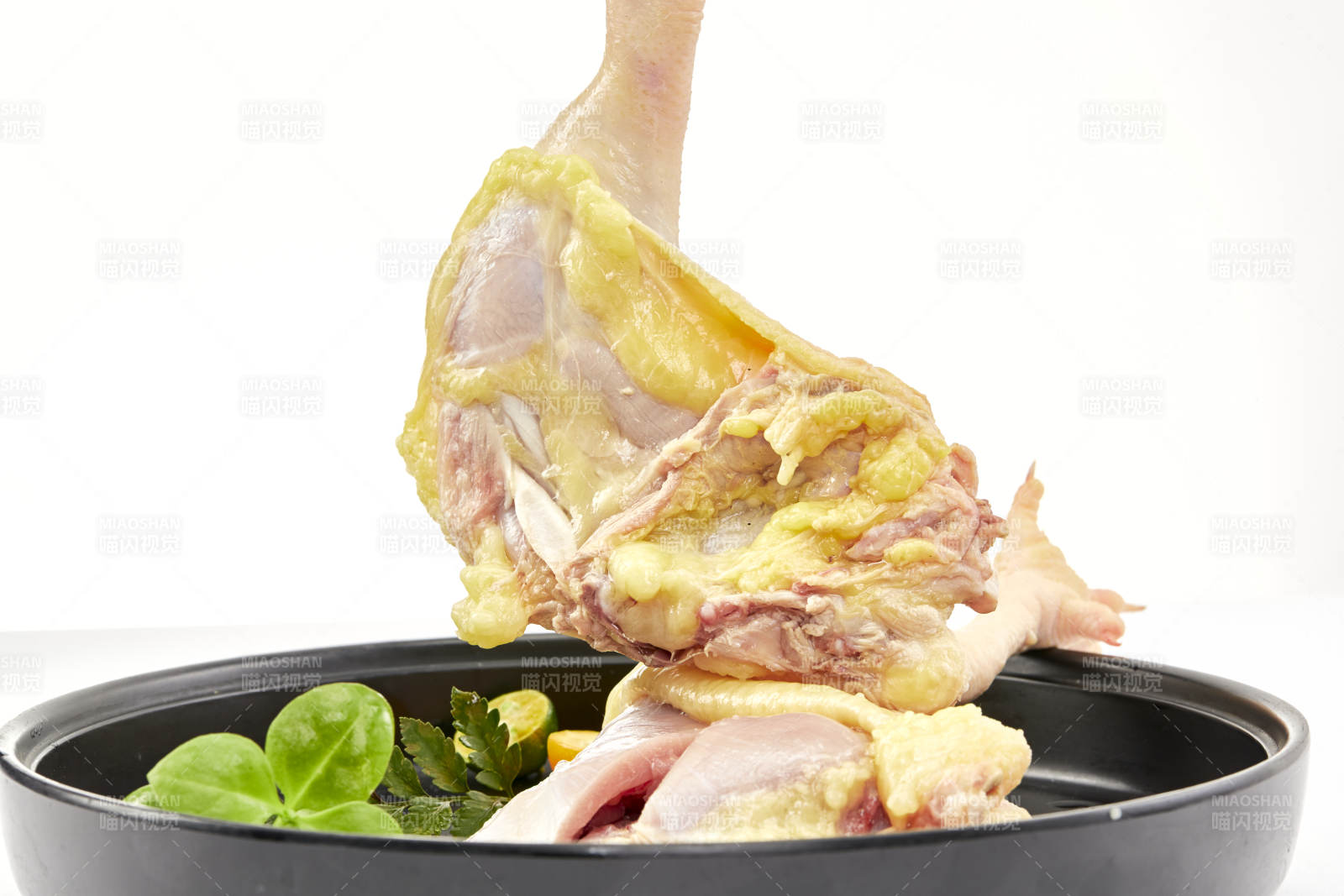 摆放在白色背景上分切好的生鲜鸡腿