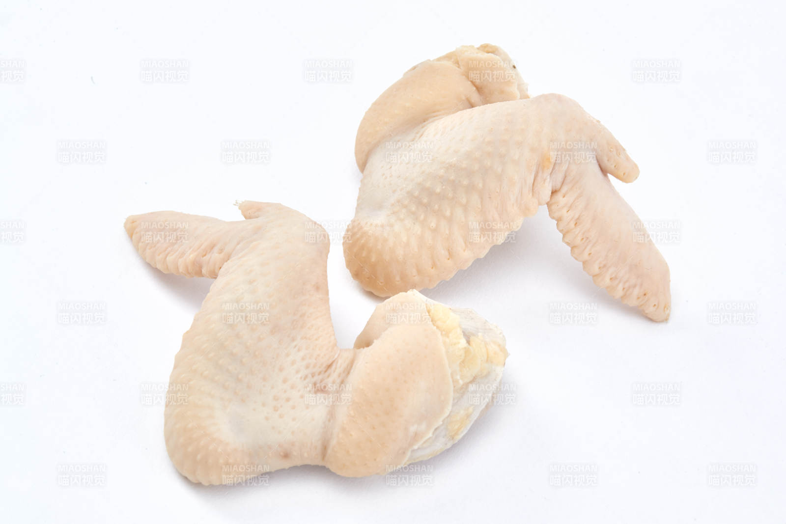 摆放在白色背景上分切好的生鲜鸡腿