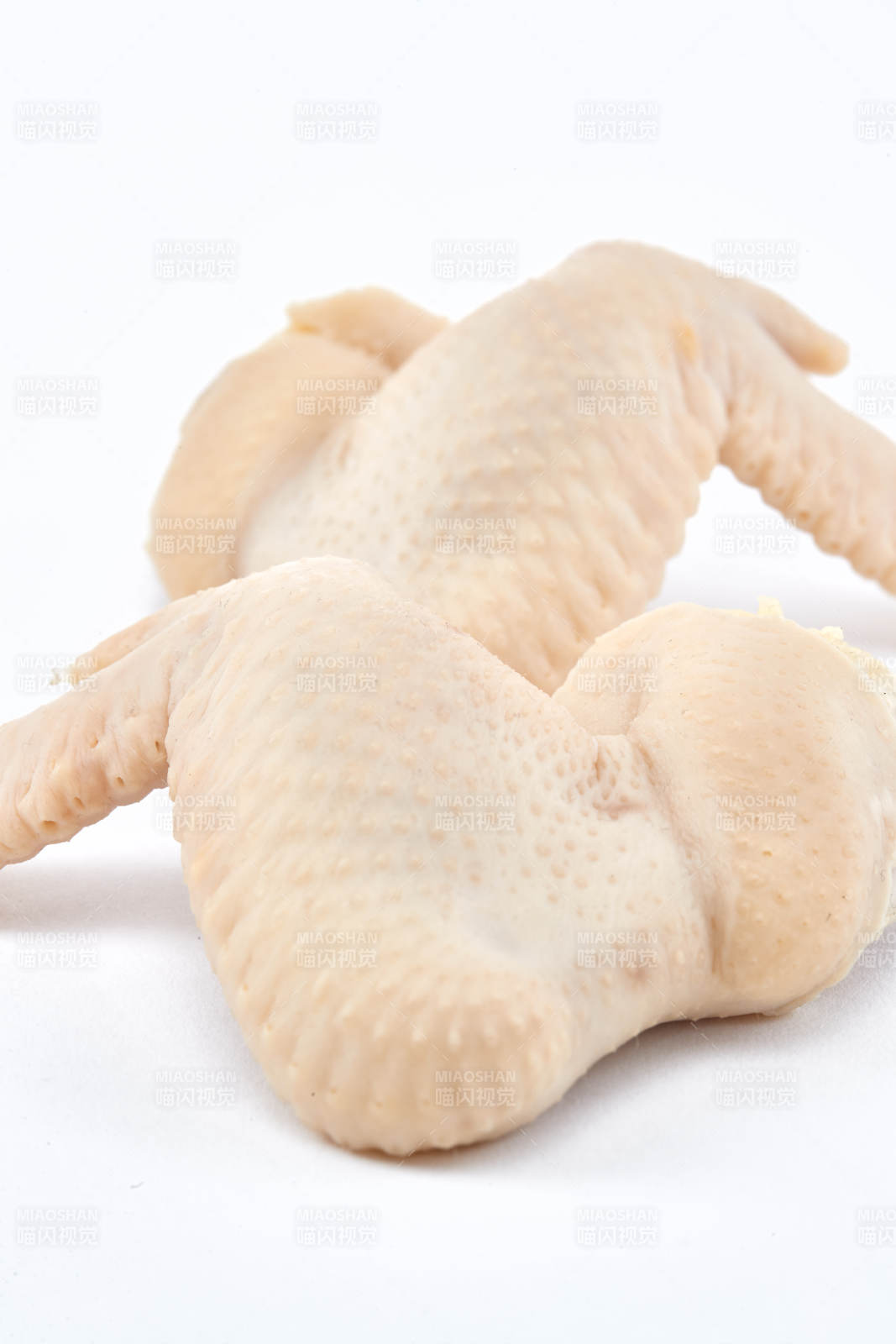 摆放在白色背景上分切好的生鲜鸡腿