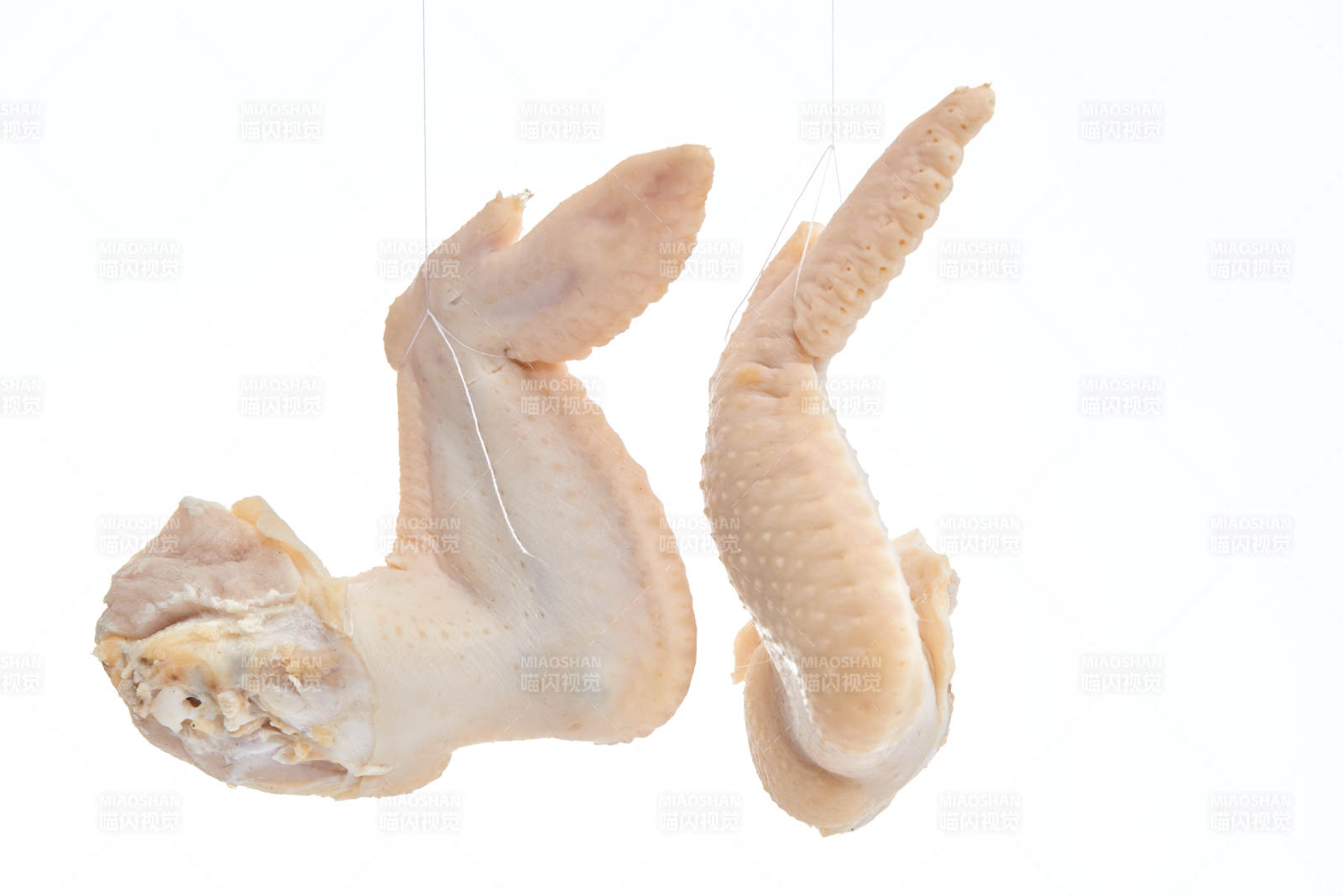 摆放在白色背景上分切好的生鲜鸡腿