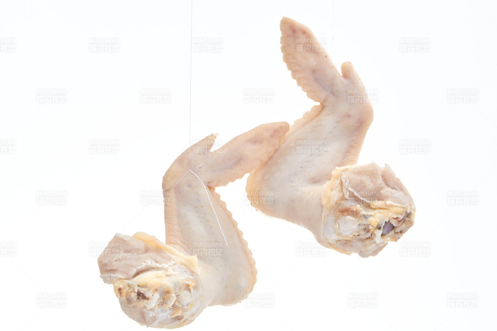 摆放在白色背景上分切好的生鲜鸡腿