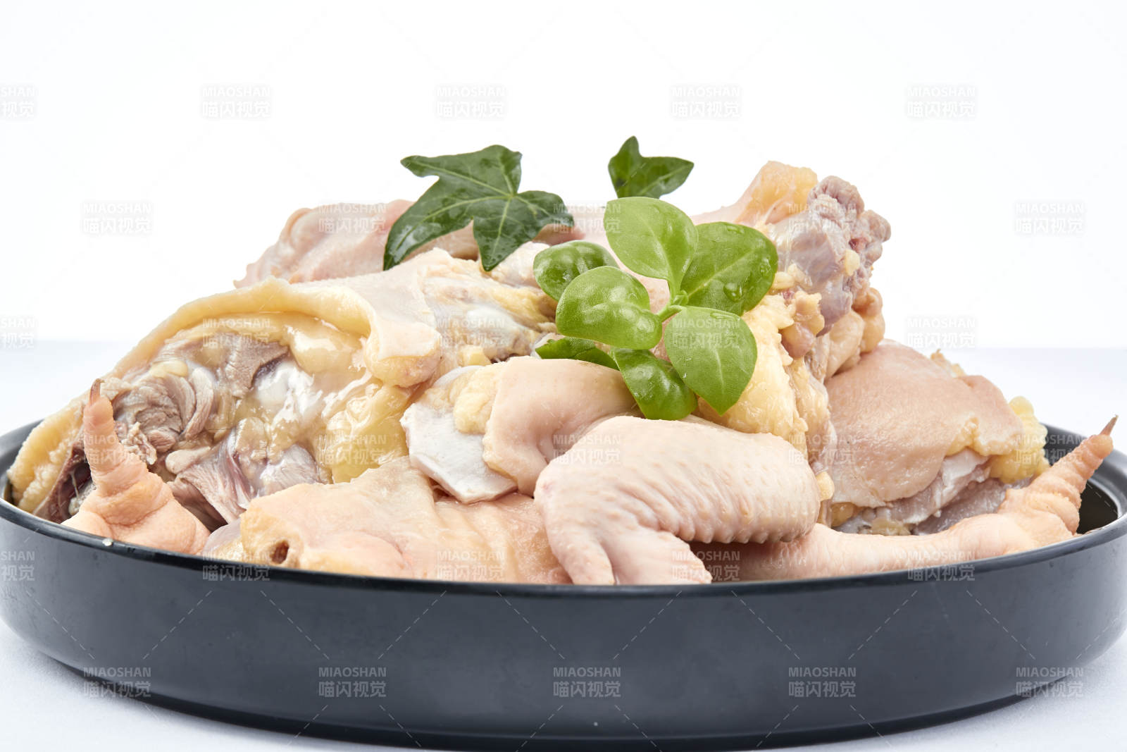 摆放在白色背景上分切好的生鲜鸡腿