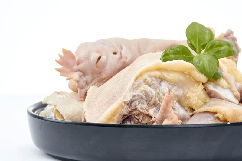 摆放在白色背景上分切好的生鲜鸡腿