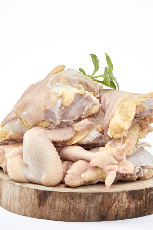 摆放在白色背景上分切好的生鲜鸡腿