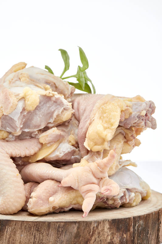 摆放在白色背景上分切好的生鲜鸡腿