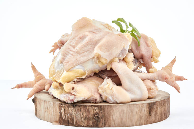 摆放在白色背景上分切好的生鲜鸡腿