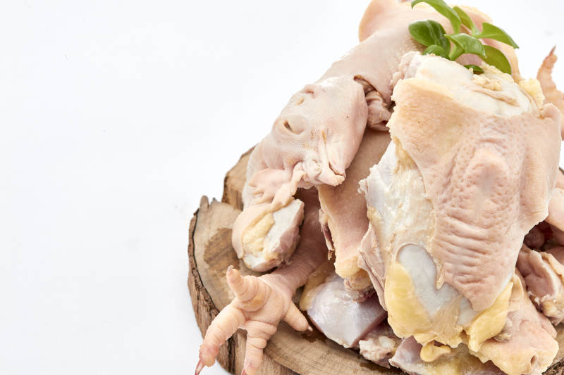 摆放在白色背景上分切好的生鲜鸡腿