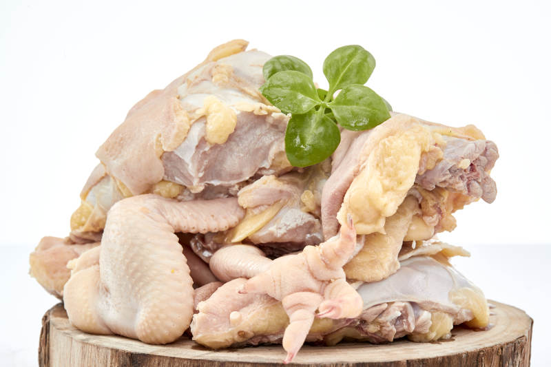 摆放在白色背景上分切好的生鲜鸡腿