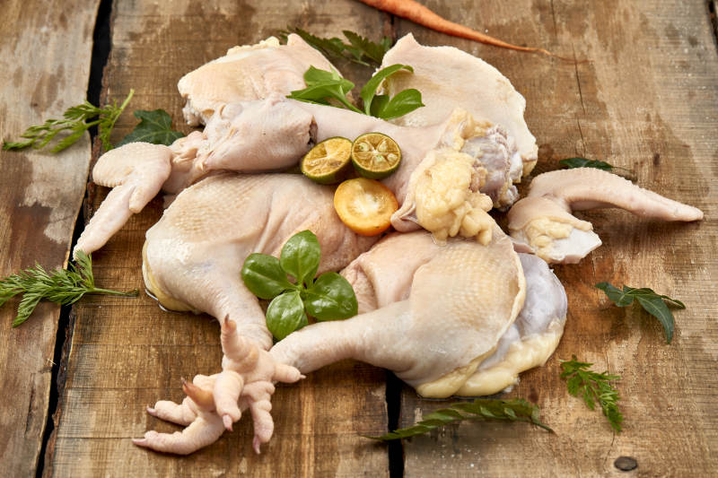 摆放在木板上的分切好的生鲜鸡肉