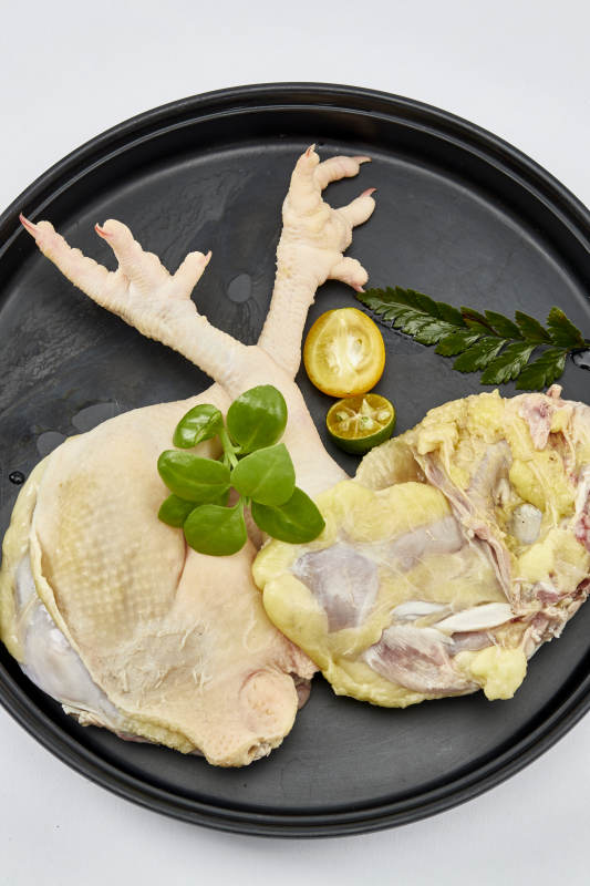 摆放在白色背景上分切好的生鲜鸡腿