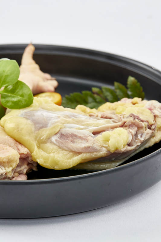 摆放在白色背景上分切好的生鲜鸡腿