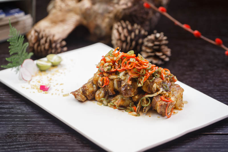 米色放瓷盘装的酸辣猪小排