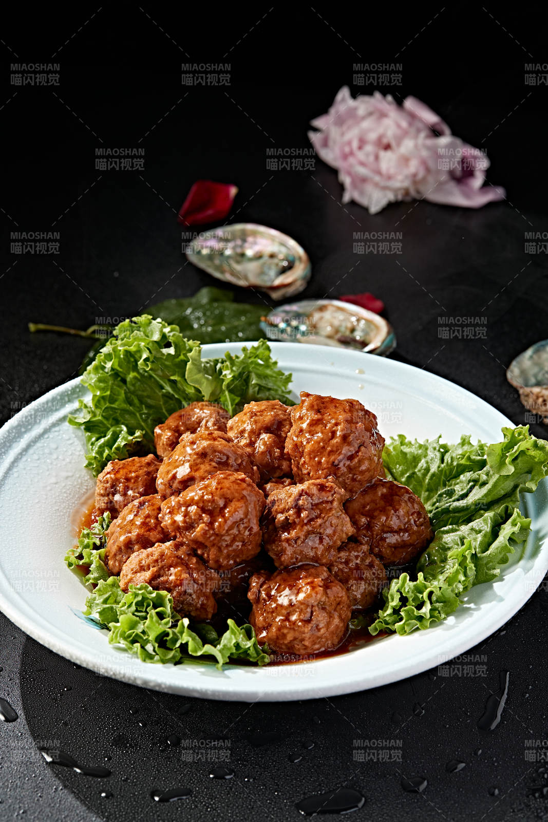 白色瓷盘装的红烧丸子