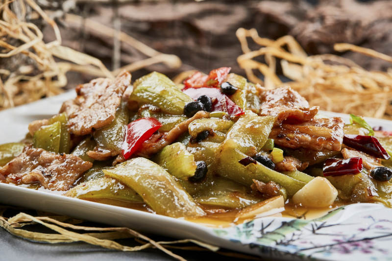 彩绘瓷盘装的猪腹肉炒丝瓜