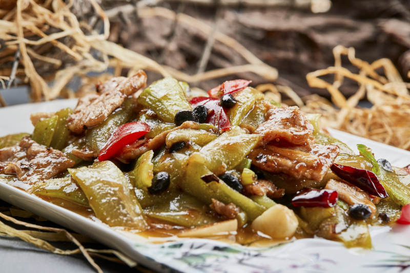 彩绘瓷盘装的猪腹肉炒丝瓜