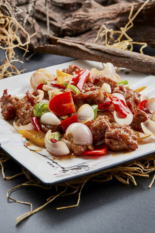 白色瓷盘装的彩椒洋葱猪小排