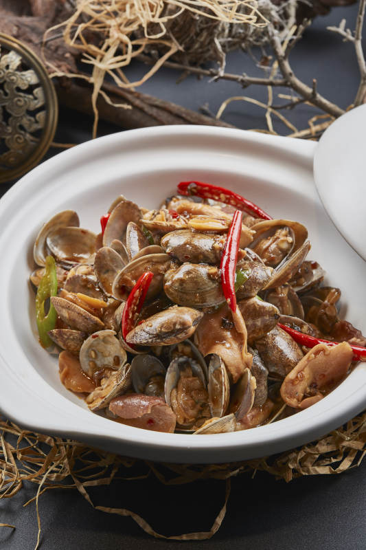 白色砂锅装的辣椒煲花蛤