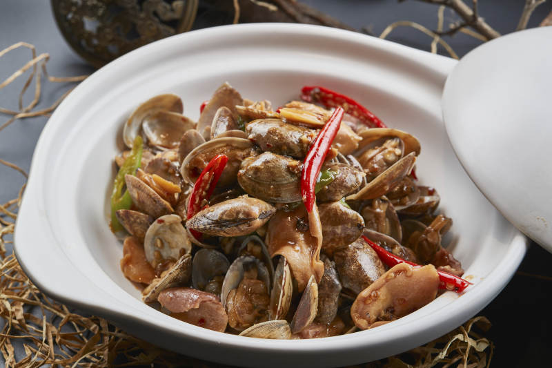 白色砂锅装的辣椒煲花蛤