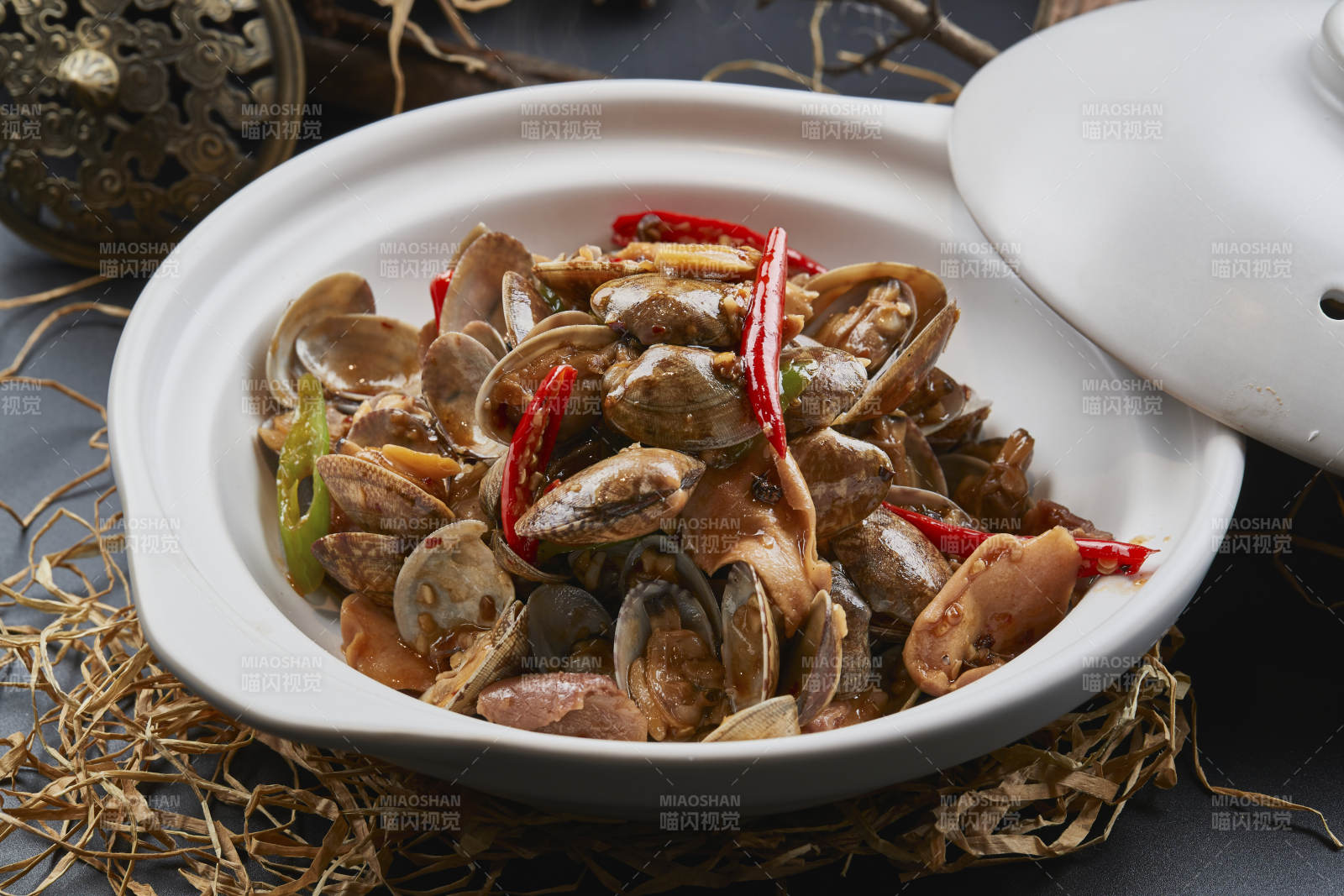 白色砂锅装的辣椒煲花蛤