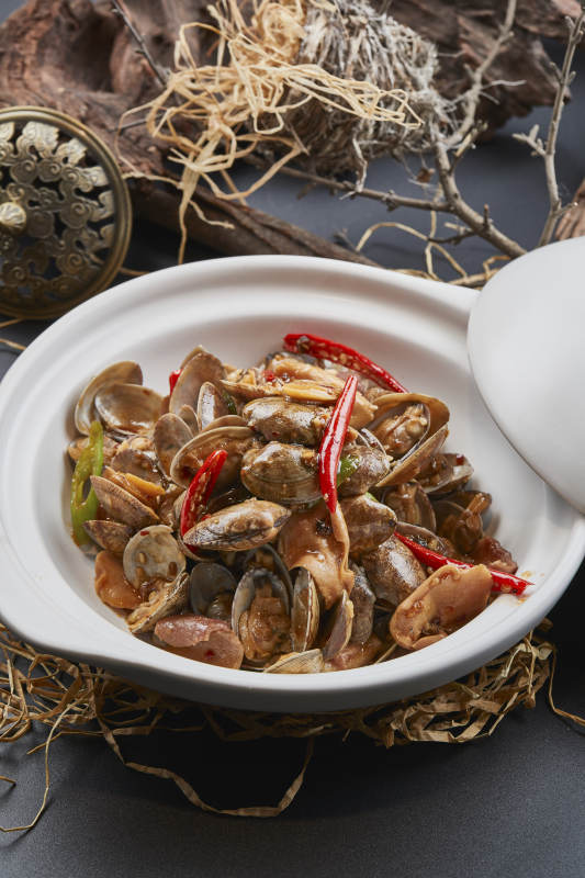 白色砂锅装的辣椒煲花蛤