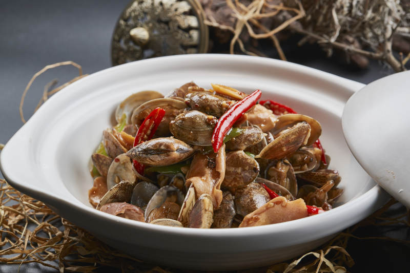 白色砂锅装的辣椒煲花蛤