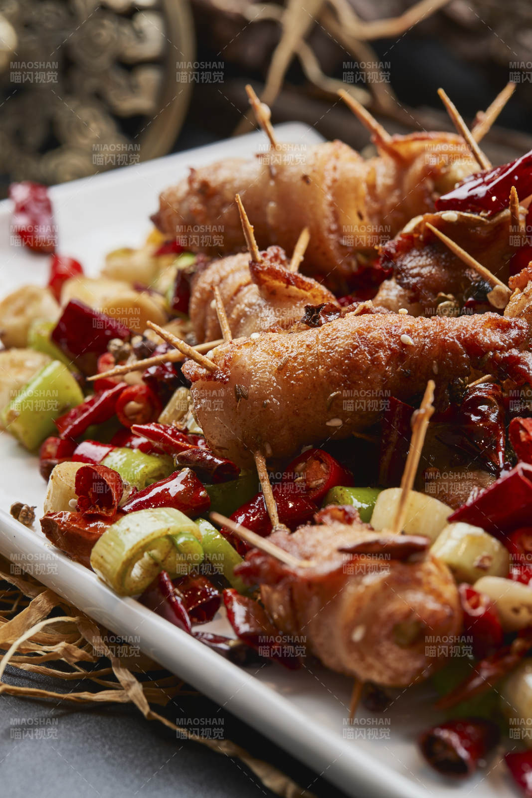 白瓷盤裝的辣子油炸五花肉山椒卷