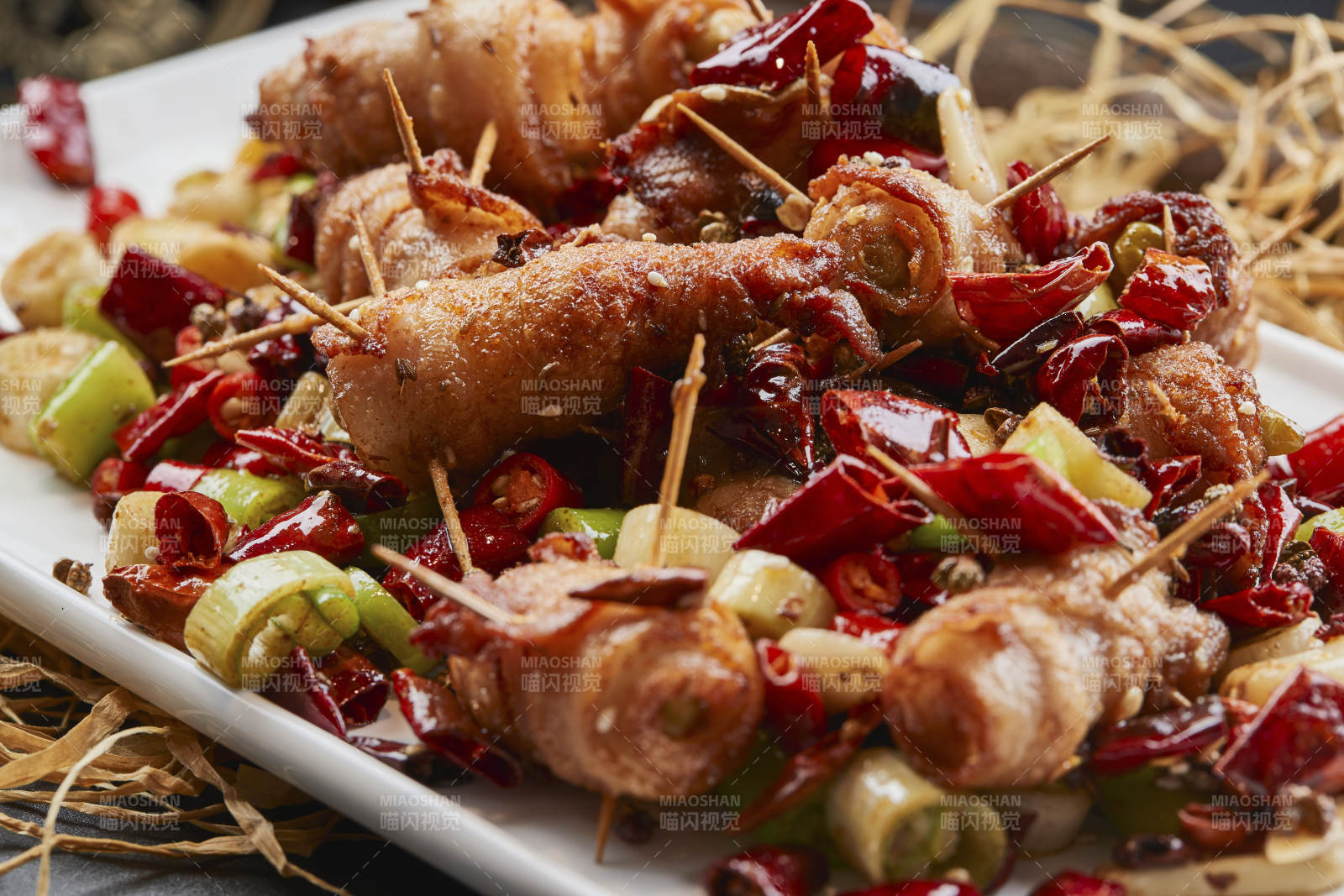 白瓷盤裝的辣子油炸五花肉山椒卷
