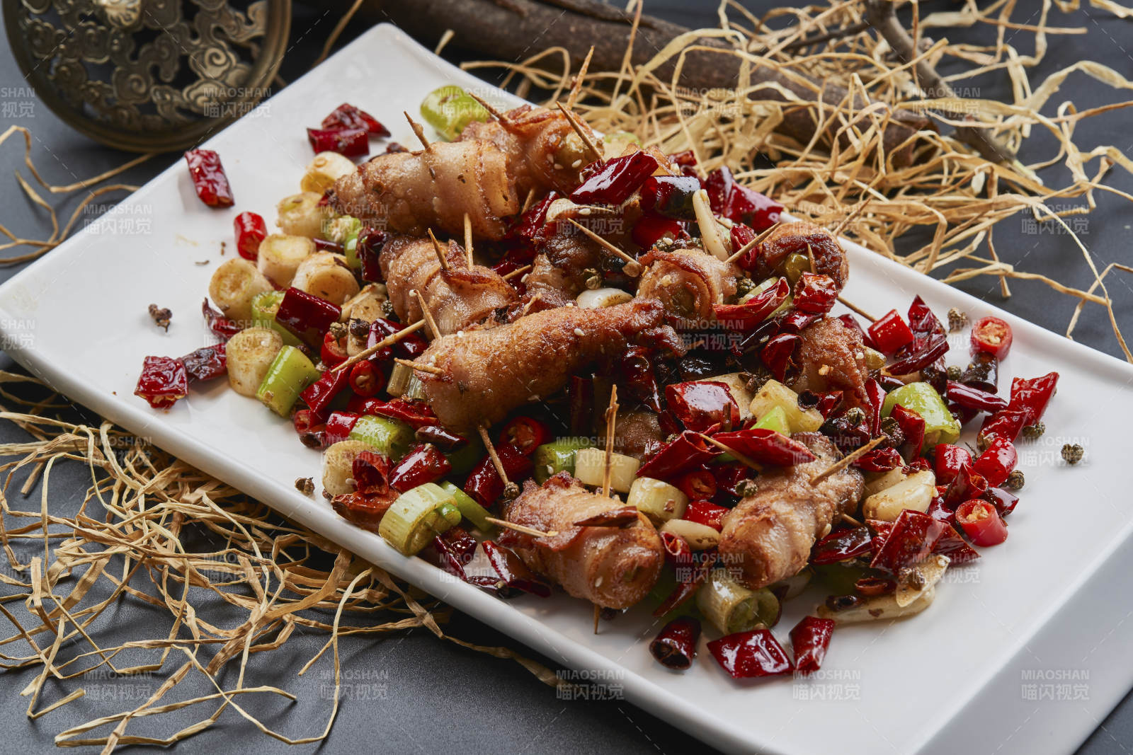 白瓷盤裝的辣子油炸五花肉山椒卷