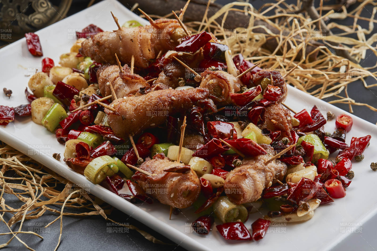 白瓷盤裝的辣子油炸五花肉山椒卷