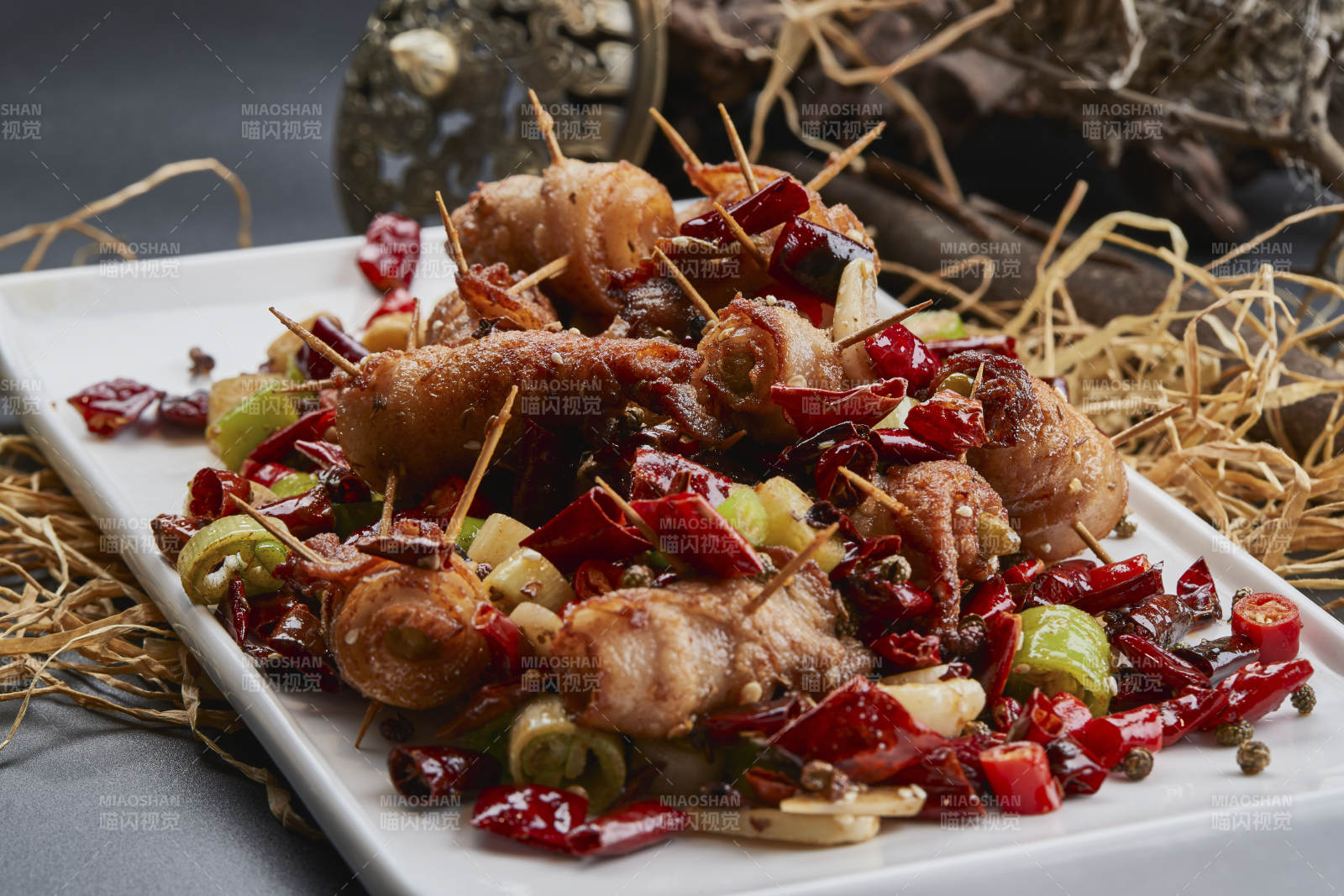 白瓷盤裝的辣子油炸五花肉山椒卷