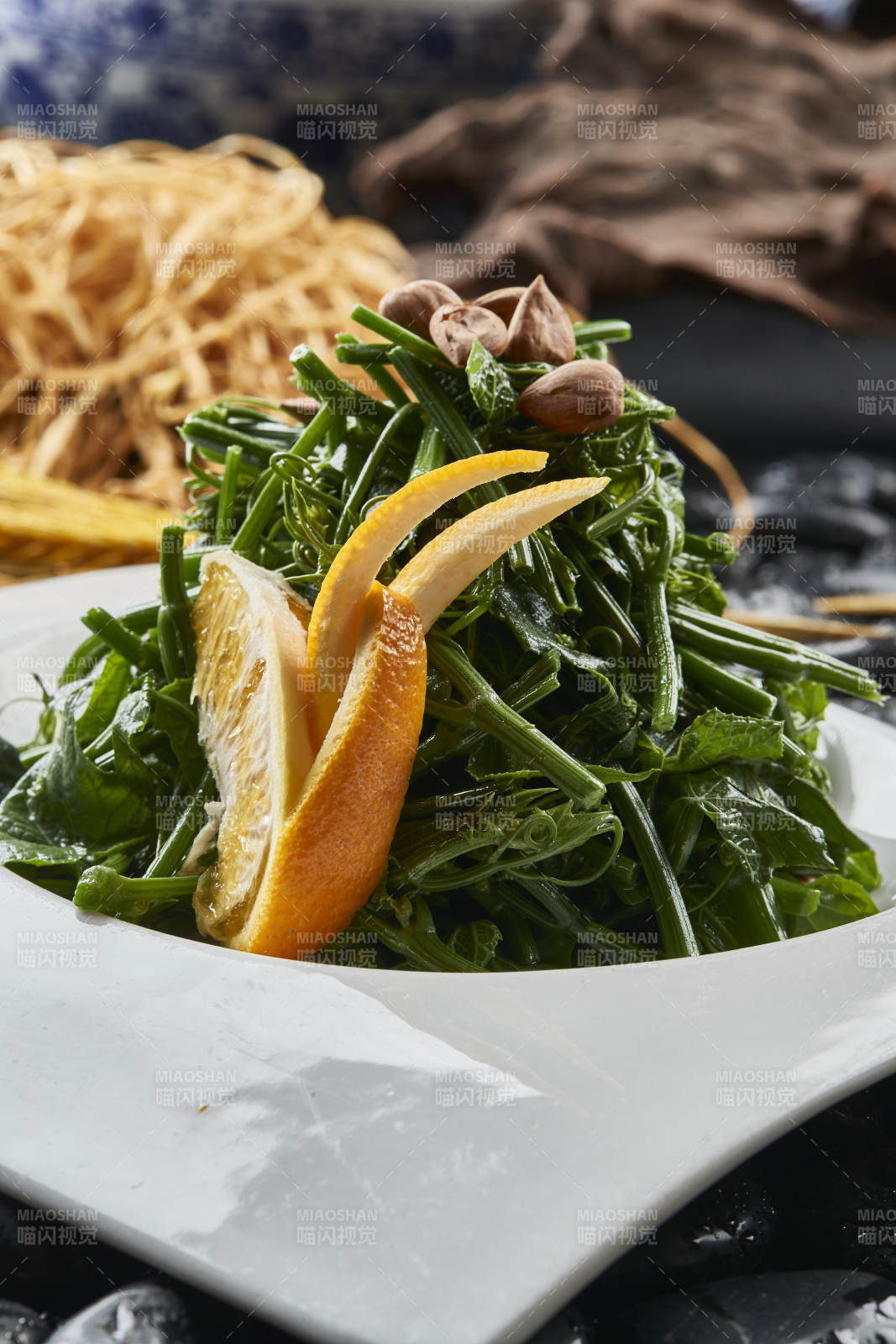 白色瓷盤裝的鮮橙杏仁兒拌蕨菜