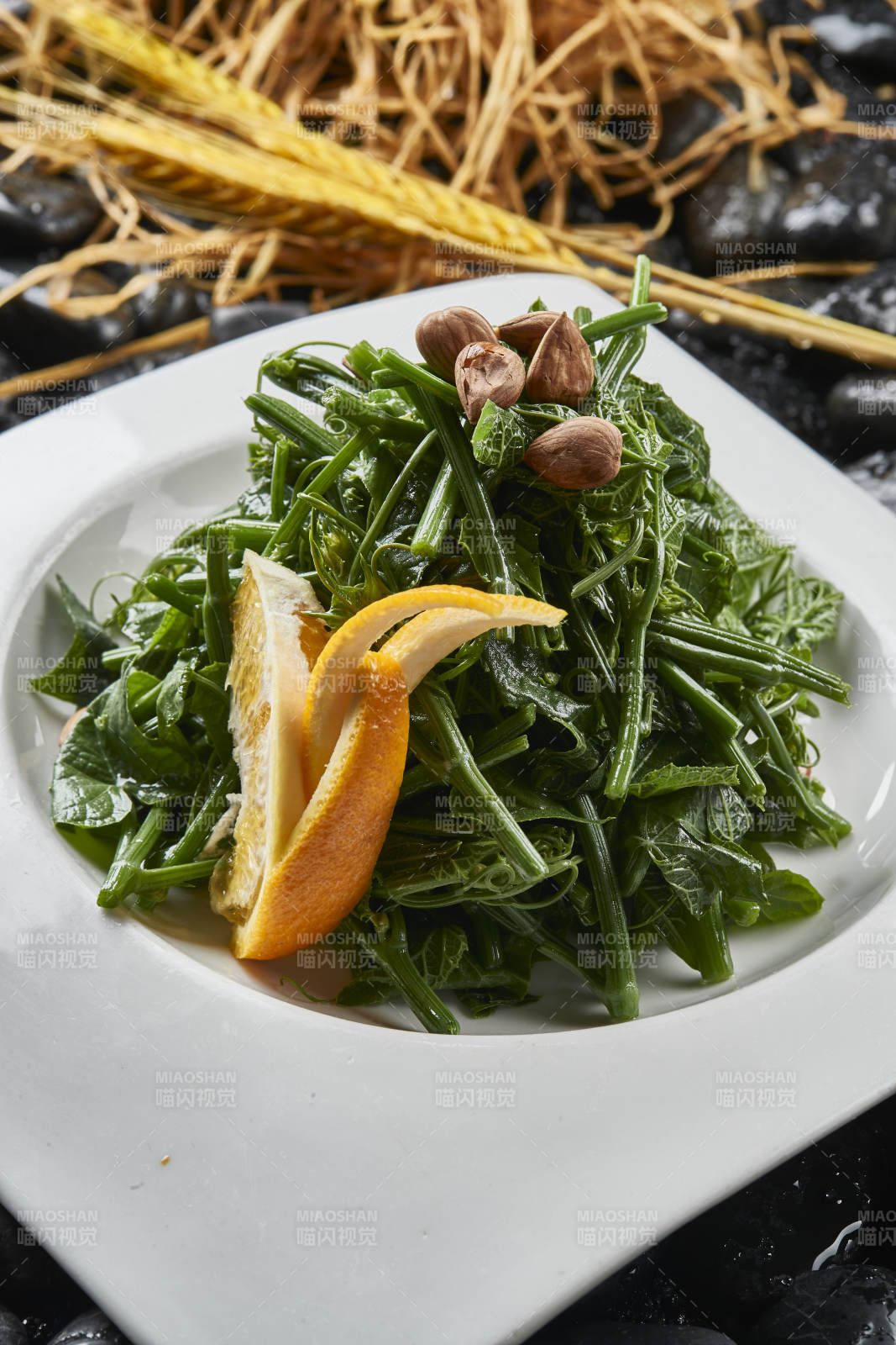 白色瓷盤裝的鮮橙杏仁兒拌蕨菜