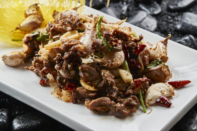 白色瓷盤裝的的孜然辣椒毛蒜燒雞胗