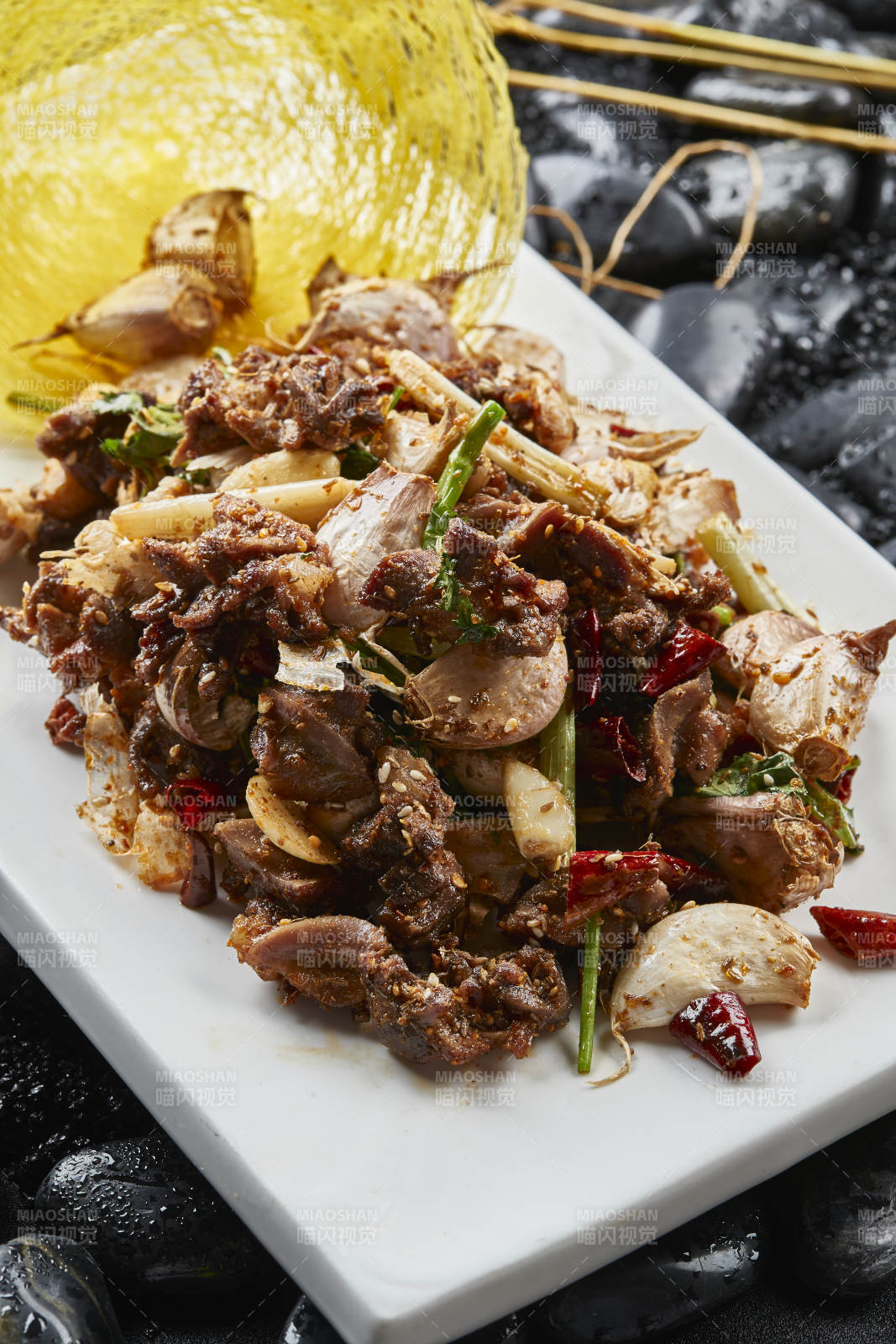 白色瓷盤裝的的孜然辣椒毛蒜燒雞胗