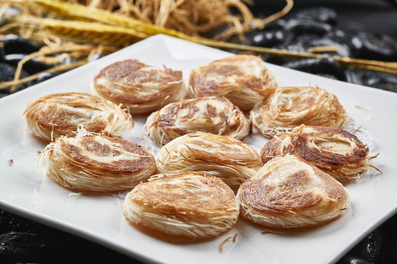 白色瓷盘装的一窝丝豆沙馅烧饼