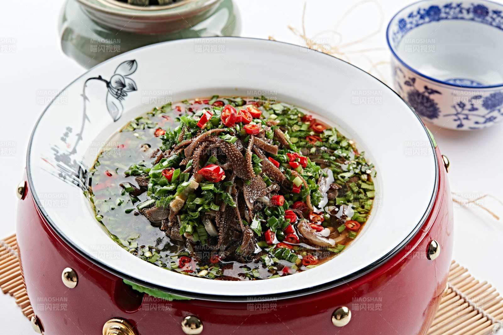 紅木底托上的白瓷盤裝的蔥香毛肚