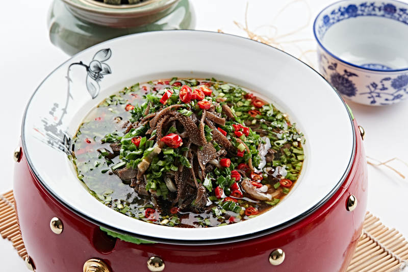 红木底托上的白瓷盘装的葱香毛肚