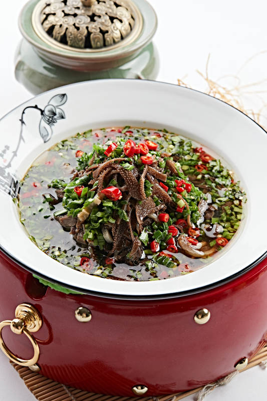 红木底托上的白瓷盘装的葱香毛肚