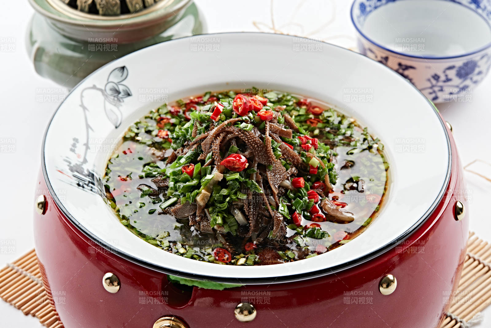 紅木底托上的白瓷盤裝的蔥香毛肚