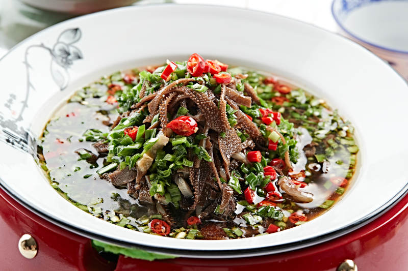 红木底托上的白瓷盘装的葱香毛肚