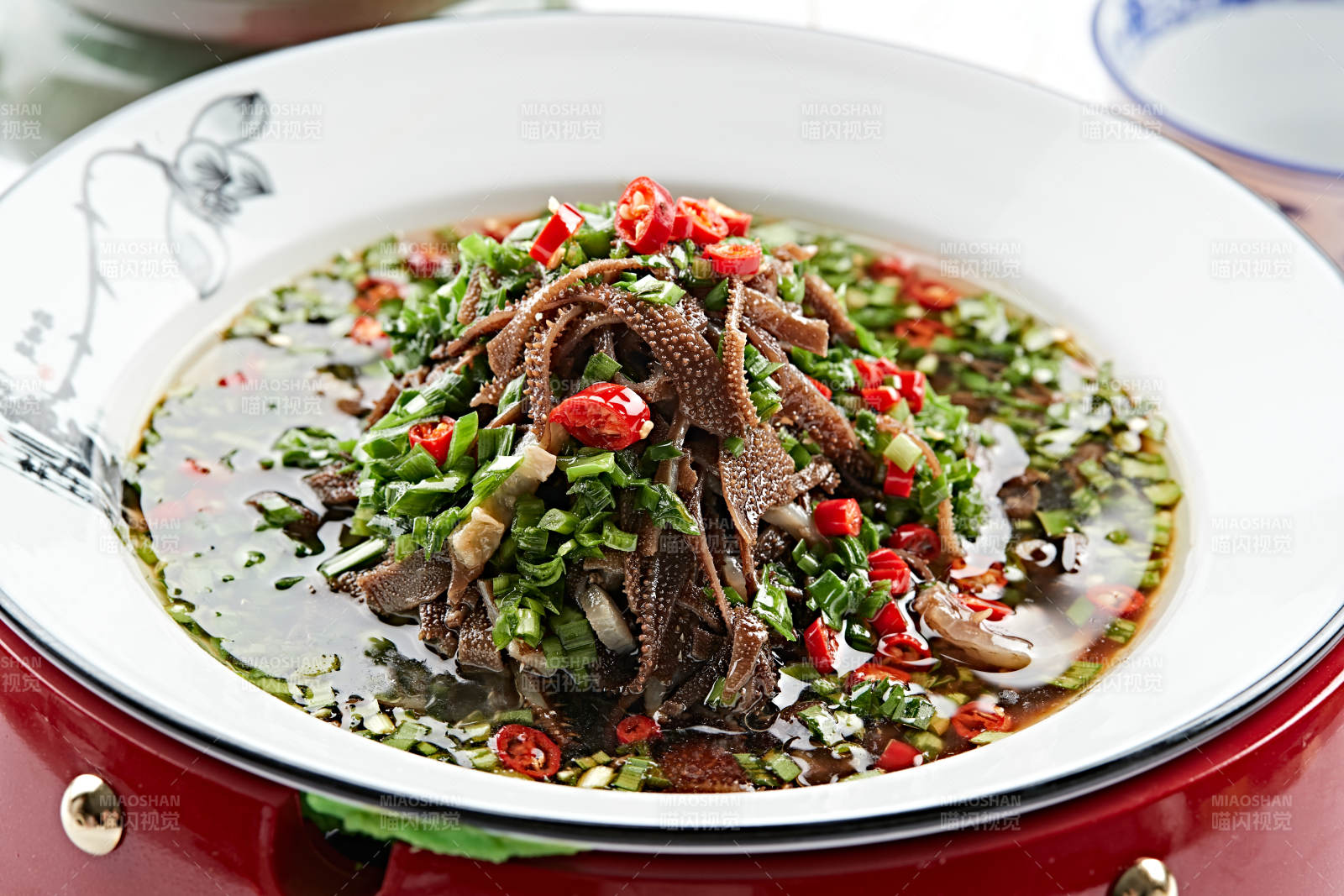紅木底托上的白瓷盤裝的蔥香毛肚