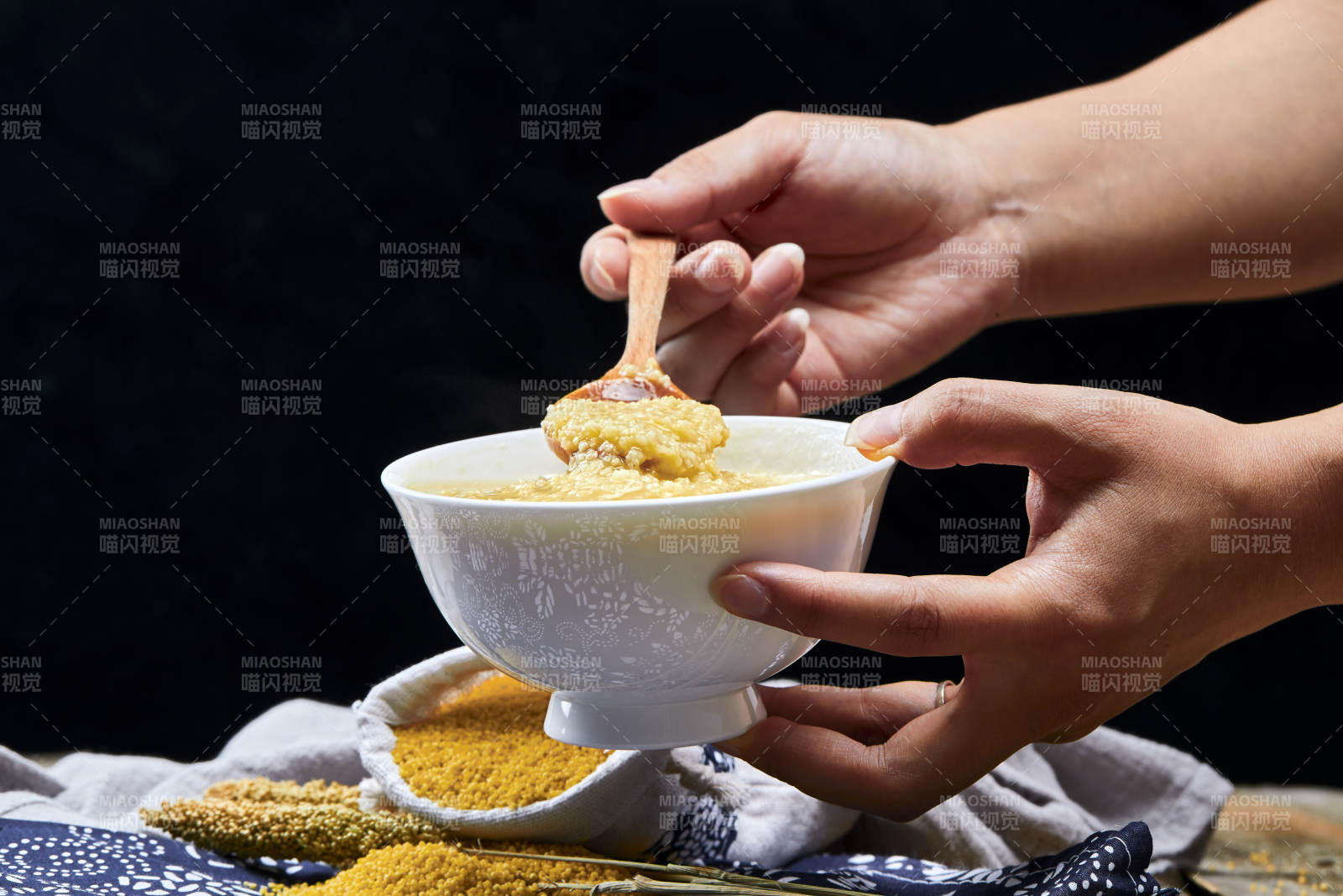 手持木勺㧟起的美味香浓小米粥