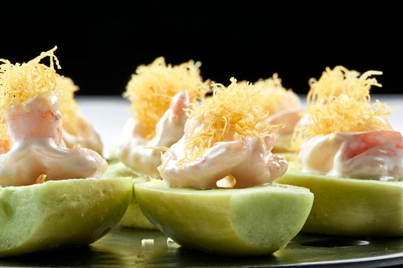 黑色瓷盘装的沙拉大虾仁